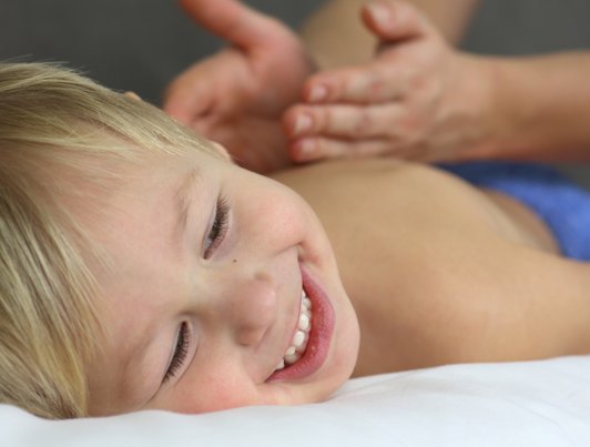 Child massage. Boy receiving healing back massage. Nurturing Touch.  
